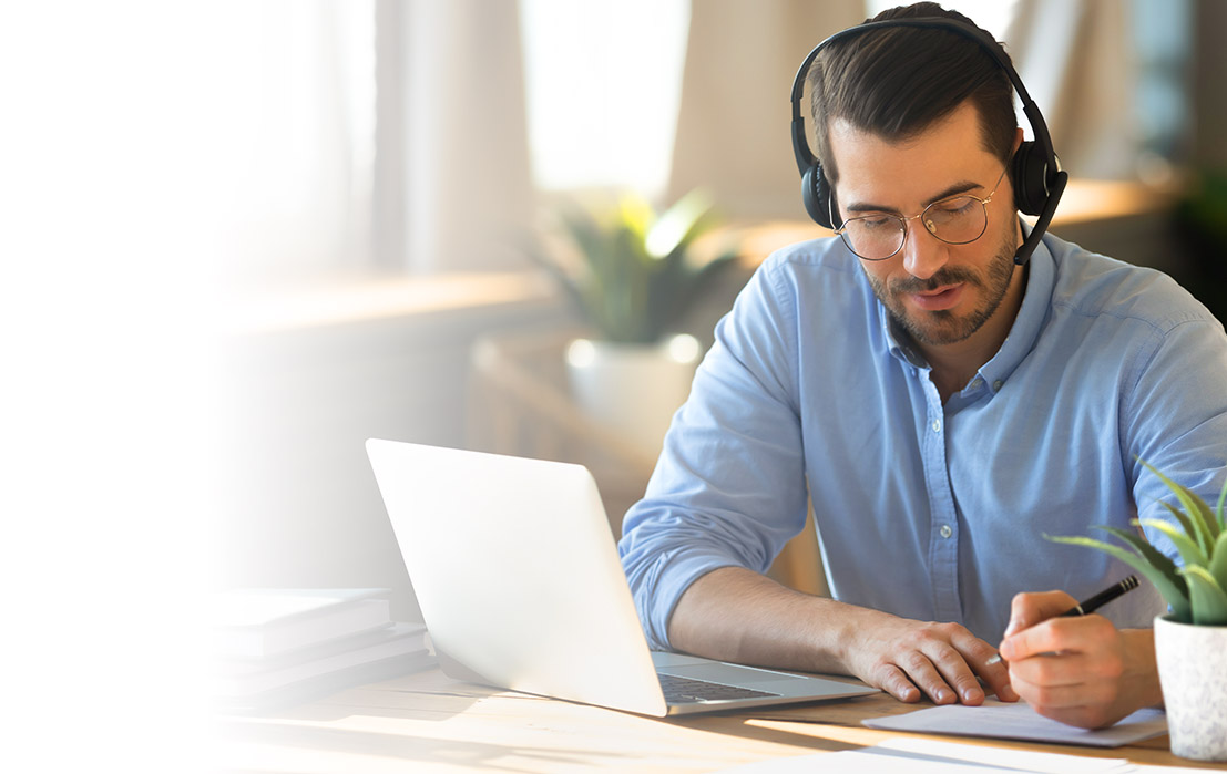 Man on a call taking notes