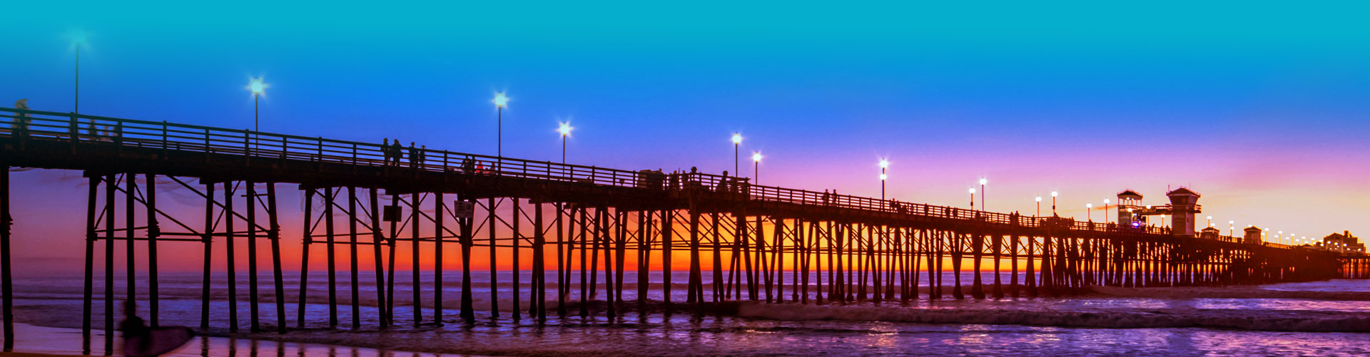 Silhouette of a bridge against an orange-purple gradient sky
