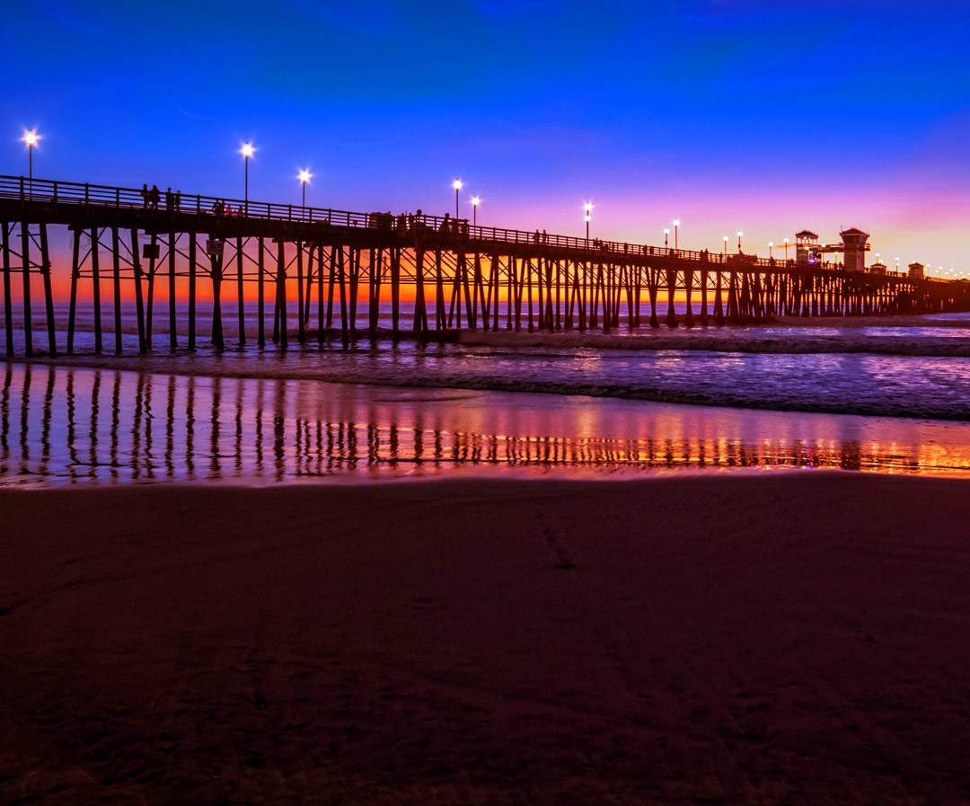 Silhouette of a bridge against an orange-purple gradient sky